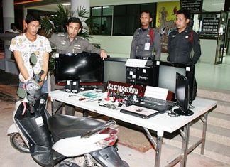 Police bring out for the cameras Ampol Saree (left), accused of stealing the Yamaha Mio and electronic equipment displayed in front of him.